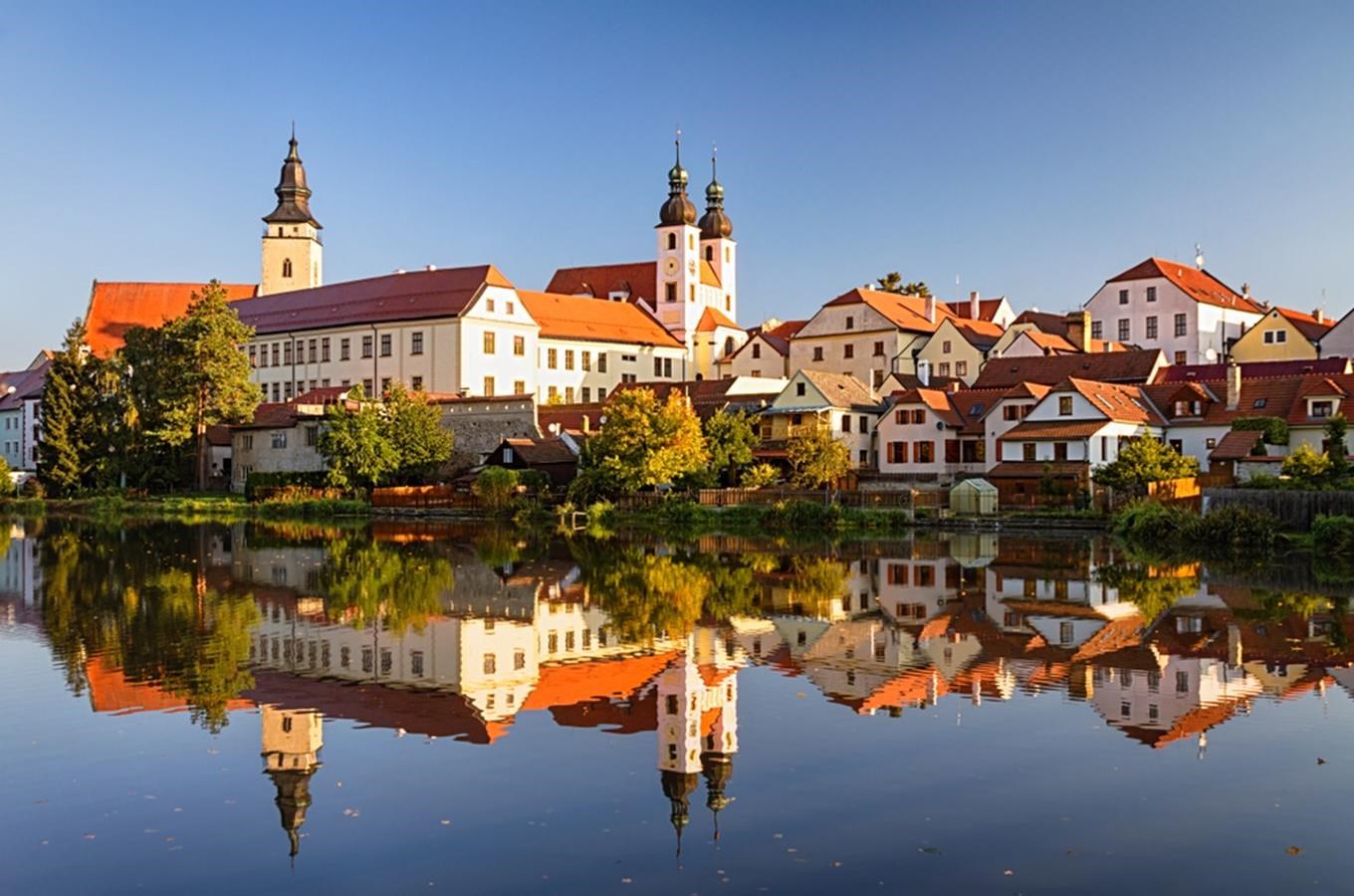 Historic town of Telč reflected in a pond